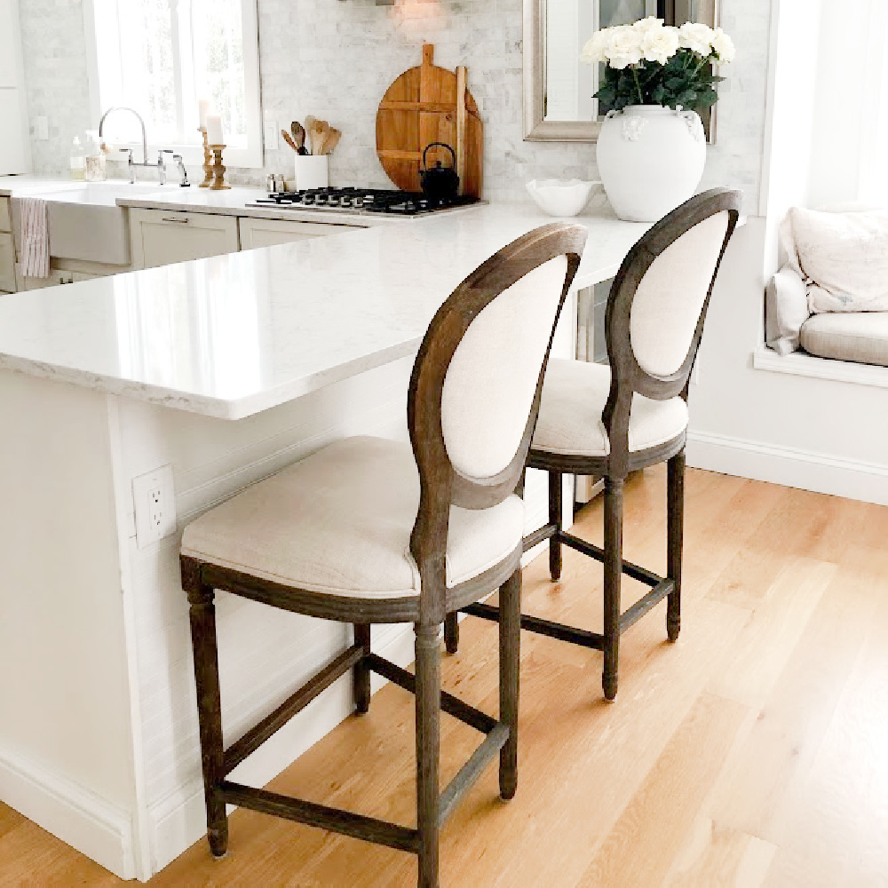White serene Shaker kitchen with Viatera Minuet quart counters, Bosch cooktop, and white oak flooring - Hello Lovely Studio. #modernfrench #whitekitchens #viateraminuet #whitequartz #kitchendesign