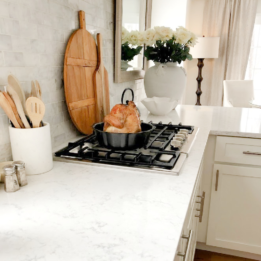 White serene Shaker kitchen with Viatera Minuet quart counters, Bosch cooktop, and modern French influence - Hello Lovely Studio. #modernfrench #whitekitchens #viateraminuet #whitequartz #kitchendesign
