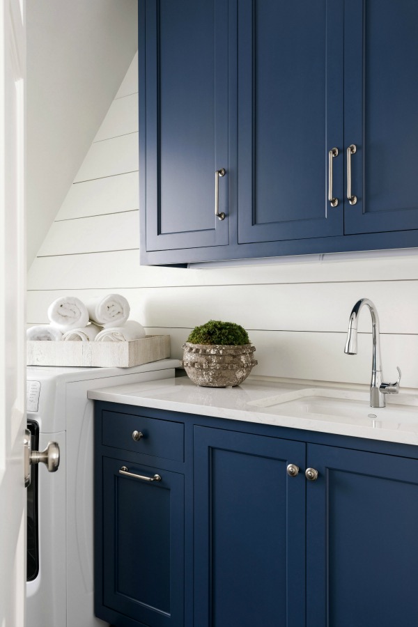 Shiplap walls and blue cabinets in a classic laundry room designed by Sherry Hart (Brookhaven). #laundryroom #shiplapwalls #bluecabinets #interiordesign