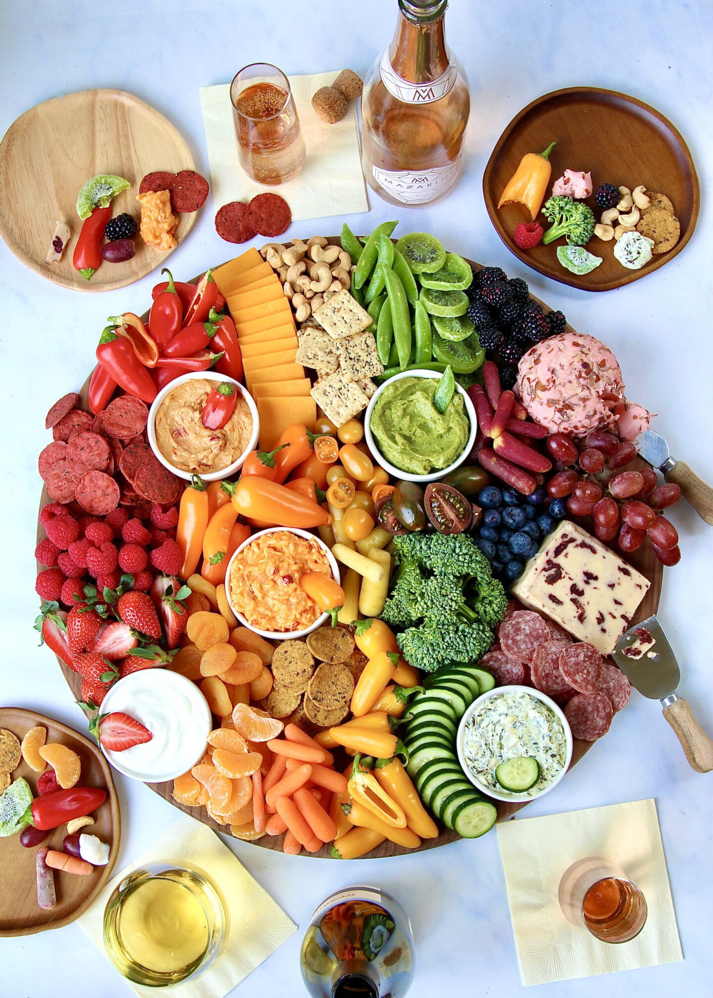 Rainbow colors on this pleasing and appetizing spring snack board by Maegan Brown of The Baker Mama! #snackboards #grazeboards #appetizers #rainbow