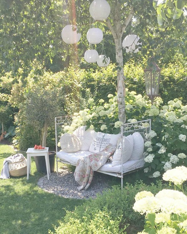 Enchanting garden with romantic daybed and paper lanterns in trees - Villa Jenal. #cotagegarden #daybed #frenchnordicstyle #romanticdecor