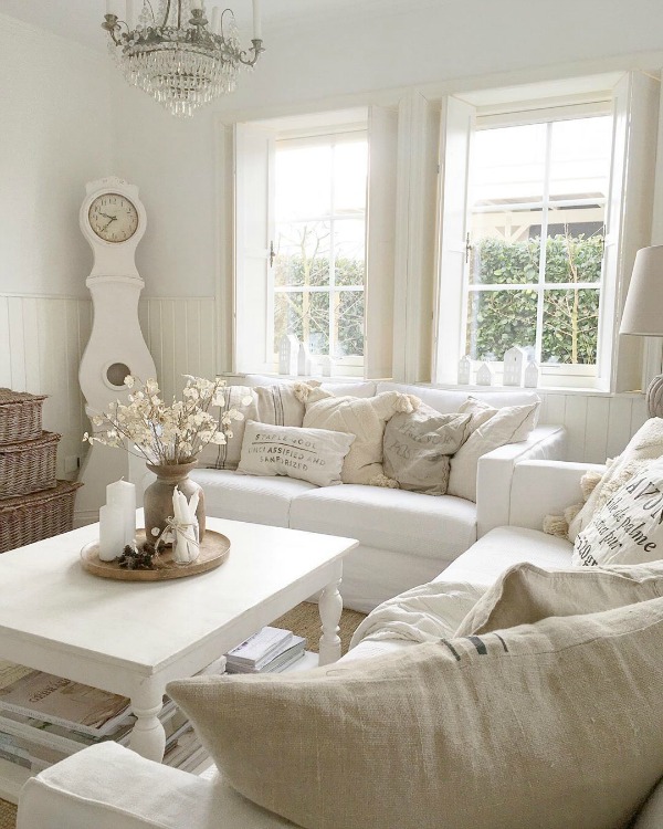 Serene and spare all white Scandi style living room with Mora clock - Villa Jenal. #frenchnordicstyle #nordicfrench #livingroom #swedishdecor #moraclock #interiordesign