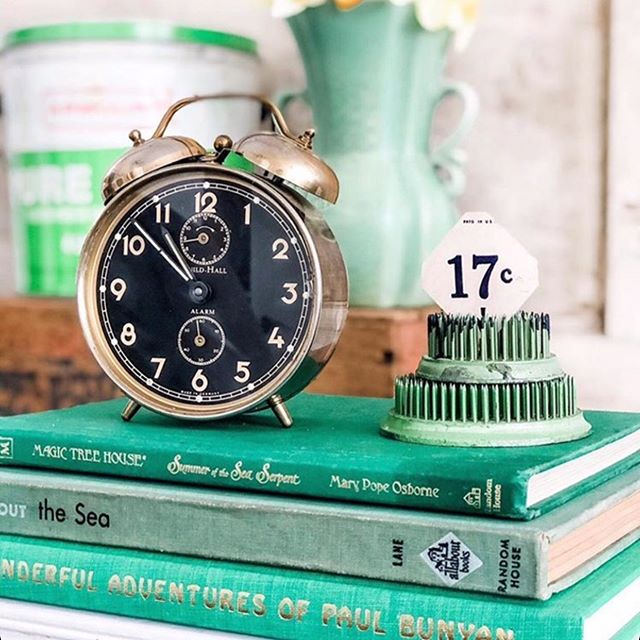 Spring green vintage books, alarm clock, and vintage treasures in a vignette by Le Cultivateur. #vintagestyle #green #vintagebooks #springgreen