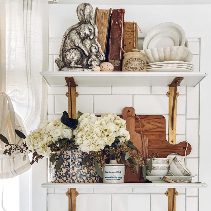 French farmhouse vintage decor on lovely white shelves in a kitchen - design by Le Cultivateur. #frenchfarmhouse #interiordesign #decorating #openshelving #vintagestyle