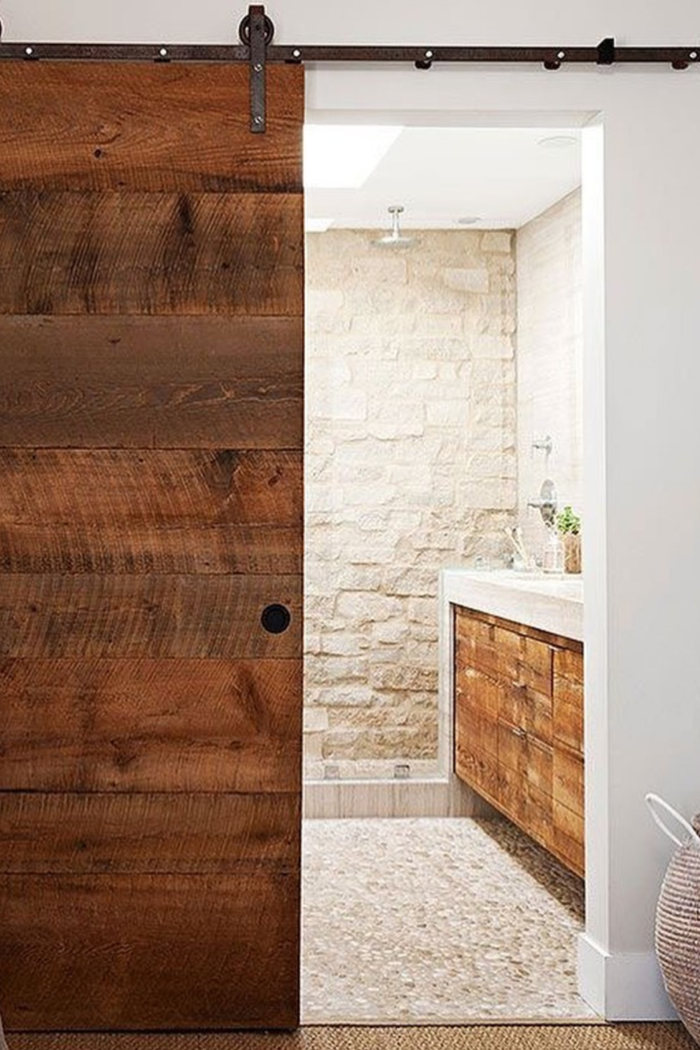 Wabi sabi natural and organic bathroom design with sliding barn door and stone clad wall - via Nuances de Vert. #organicdesign #wabisabi #bathroomdesign