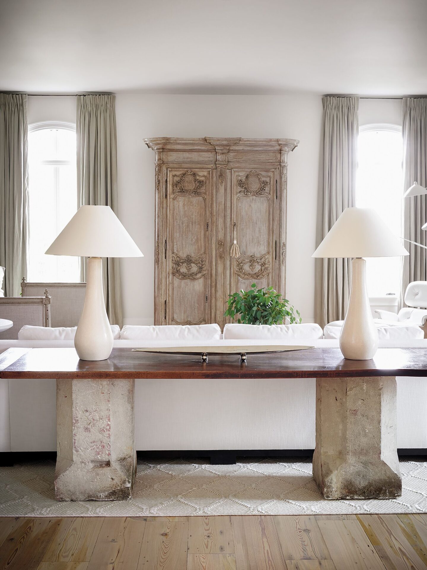 Antique 18th century sandstone garden plinths combine with a 19th century walnut plateau to form a custom console behind the sofa in a living area designed by Tara Shaw. #europeanantiques #oldworldstyle #modernfrench #tarashaw #livingroom #interiordesign