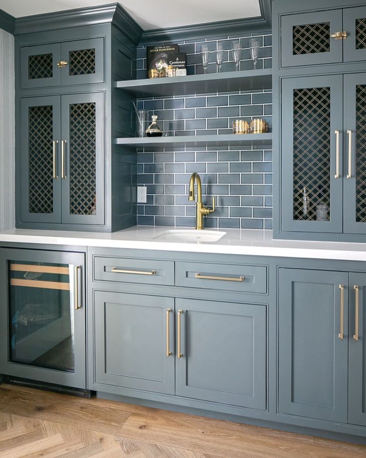 Gorgeous blue grey painted custom wet bar with subway tile and decorative inset grills in cabinet doors. Design: AGK Design Studio; Builder: @themeterco. #wetbar #bluegrey #customcabinetry #cabinetgrills