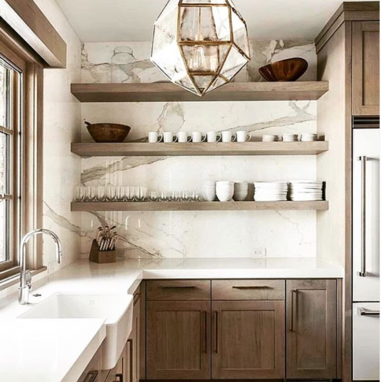 Gorgeous greyed wood cabinets and apron front farm sink in a gorgeous sophisticated neutral kitchen with elegant design. #farmsink #floatingshelves #kitchendesign