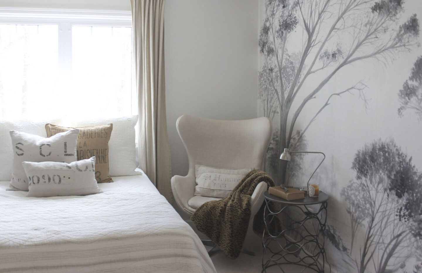 Lovely grisaille mural wallpaper from Photowall with grey trees on a white ground. I created a DIY accent wall in a guest bedroom, and the mood is timeless, serene and tranquil - Hello Lovely Studio. #wallpaper #mural #interiordesign #hellolovelystudio #grisaille #treewallpaper