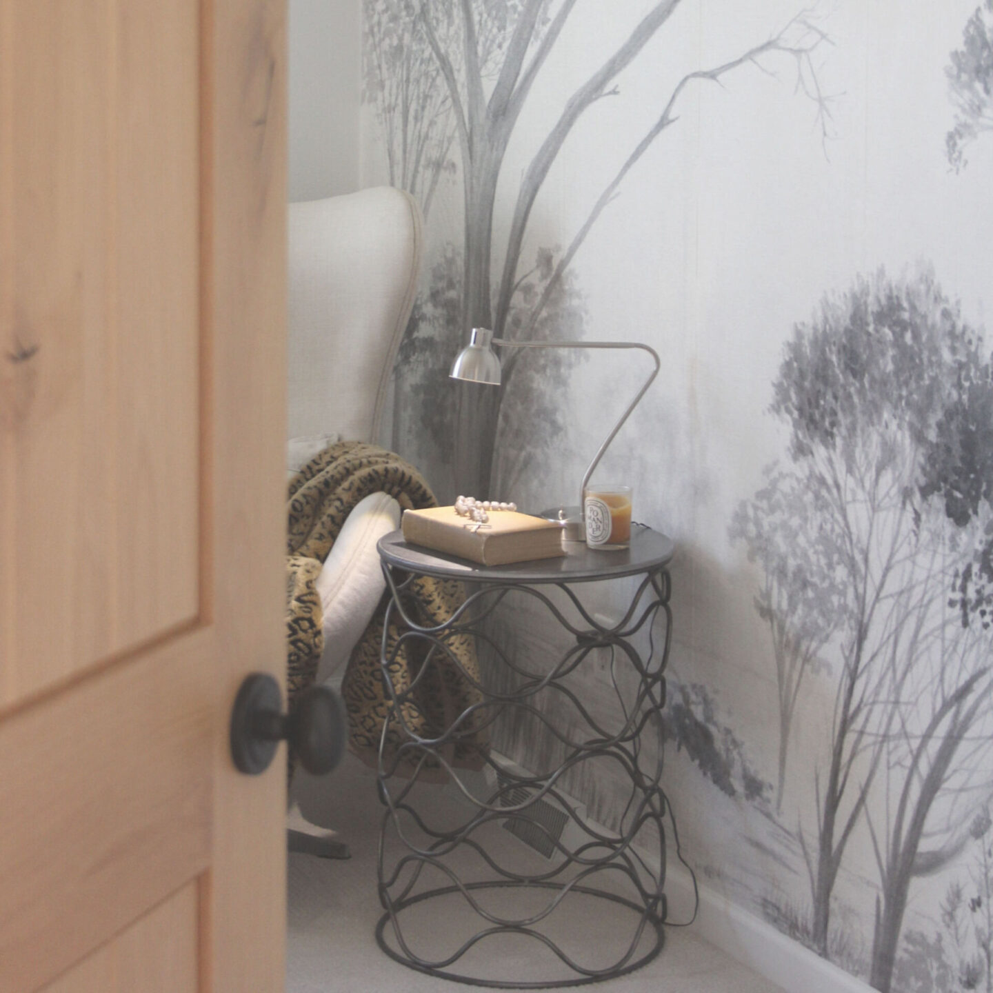 Hello Lovely's guest bedroom with grisaille tree mural (Photowall) and rustic alder door.