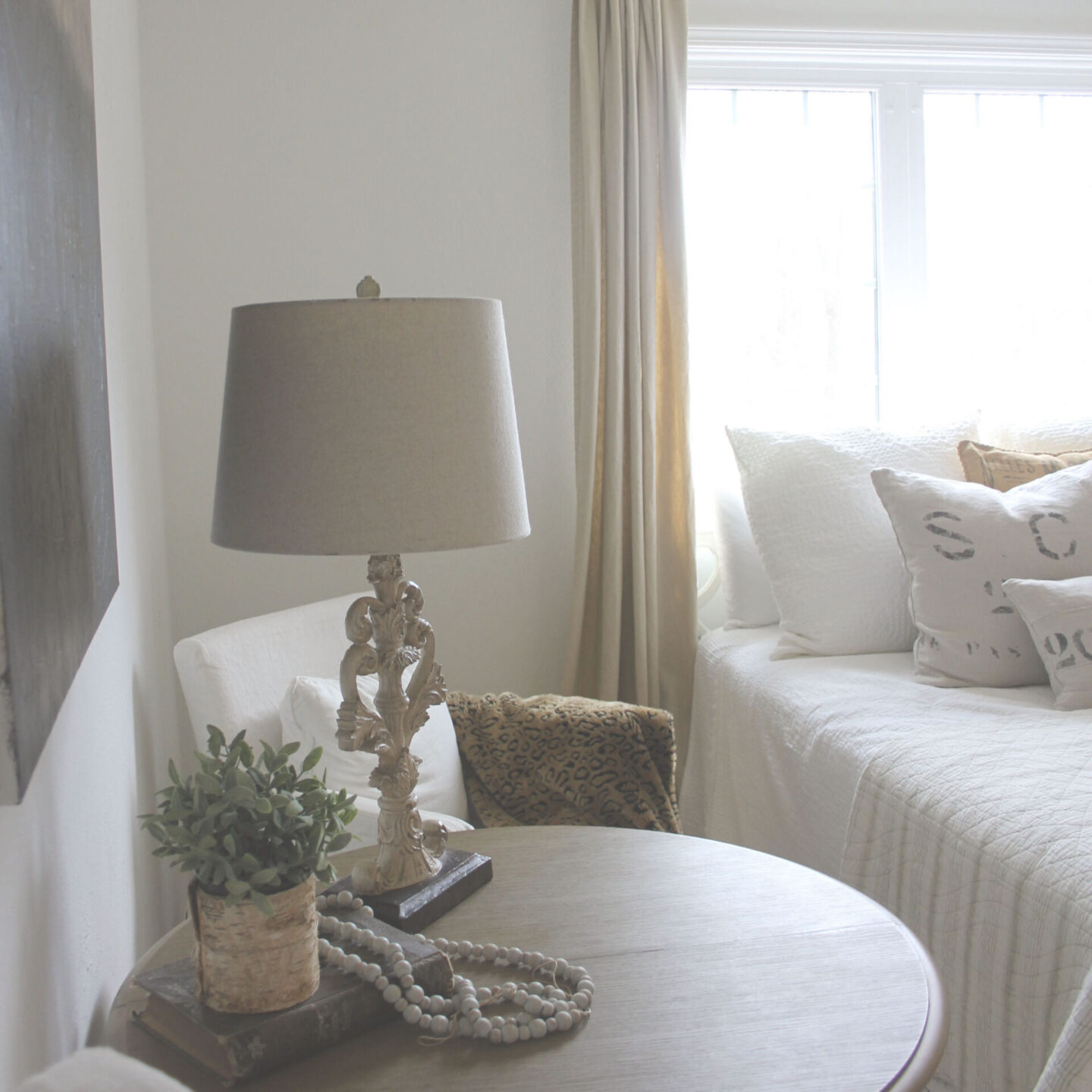 White linen slipcovered chairs and round French table in a bedroom used as an office with abstract painting by Michele - Hello Lovely Studio. #abstractpainting #hellolovelystudio #europeancountrydecor #interiordesign