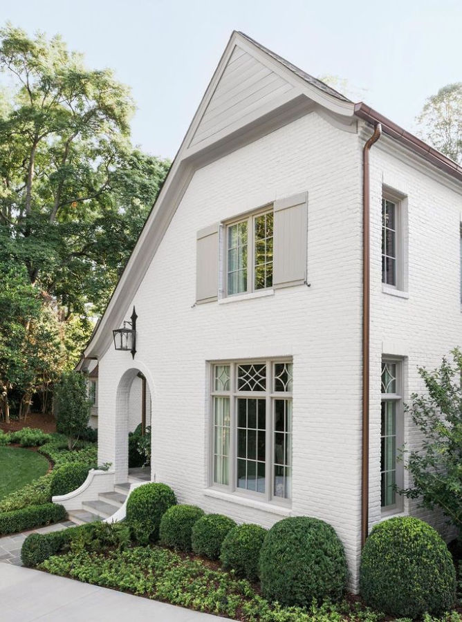 White brick home (Balboa Mist) with arched entrance and light gray trim and shutters (SW Amazing Gray) - Ladisic Fine Homes & Sherry Hart.. #benjaminmoore #balboamist #swamazinggray #houseexterior #paintcolors