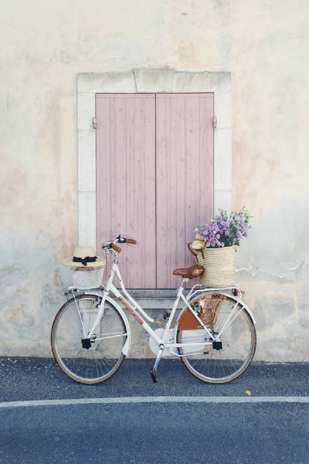 Dusty rose pink shutters on a stucco sided rustic French home with charming bicycle and French market basket (Vivi et Margot). #vivietmargot #bicycle #pink #frenchfarmhouse #frenchbasket #marketbasket #romanticdecor