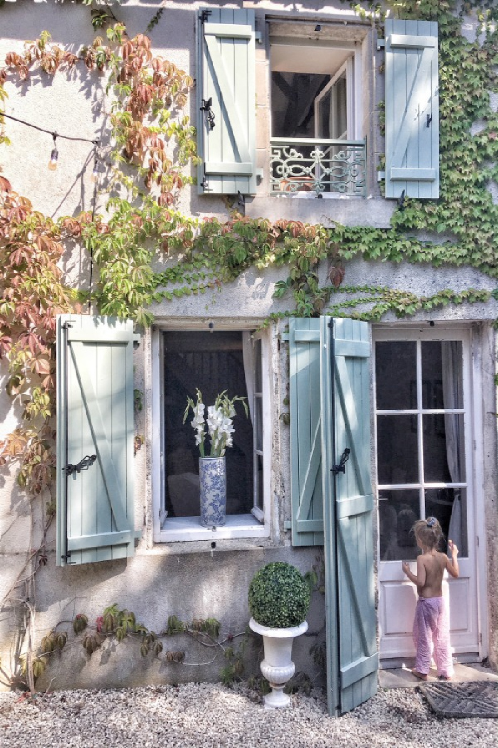 Green shutters and climbing vines on a breathtaking French farmhouse exterior. Vivi et Margot! Come be inspired by this house tour on Hello Lovely. #vivietmargo #frenchfarmhouse #climbingvines #exterior #greenshutters #vertolivier #romanticdecor #frenchcountry #europeanfarmhouse