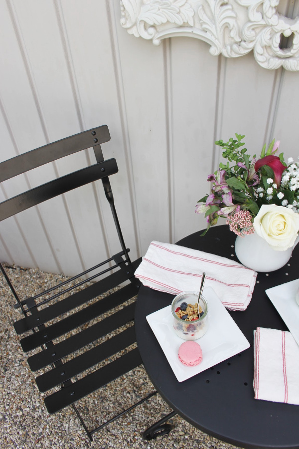 Black bistro chair and outdoor oasis dining with French country romance and a table set for brunch. #hellolovelystudio #cafechairs #frenchbistro #modernfrench #bistrochairs #outdoordining #patiofurniture #outdoorfurniture