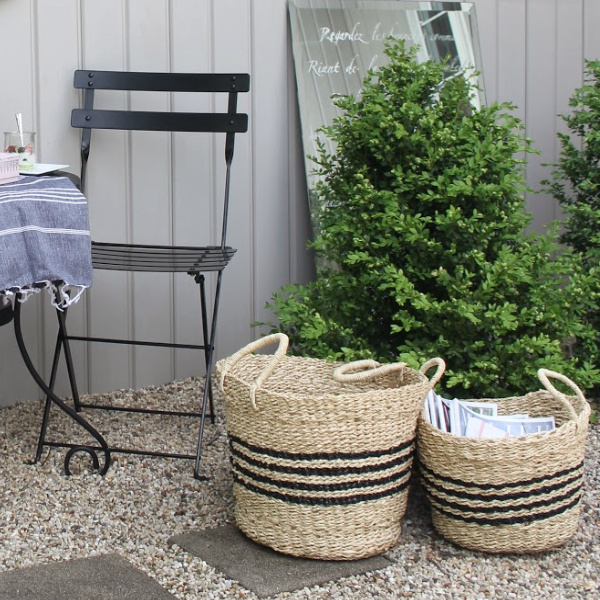 Seagrass Rrench baskets with stripes, Turkish towel runner, and outdoor oasis dining with French country romance and a table set for brunch. #hellolovelystudio #frenchbistro  #frenchbaskets #frenchcountrydecor #modernfrench #bistrochairs #outdoordining #seagrassbasket #turkishtowel