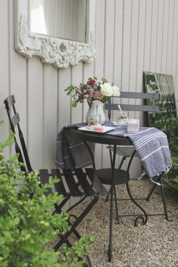 Black bistro set, Turkish towel runner, and outdoor oasis dining with French country romance and a table set for brunch. #hellolovelystudio #frenchbistro #modernfrench #bistrochair #outdoordining #turkishtowel