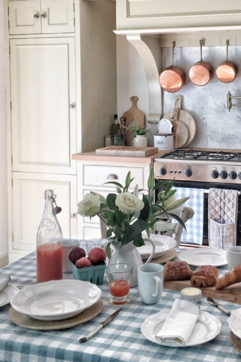 This charming kitchen near Bordeaux is rustic and romantic thanks to French homewares from Vivi et Margot. #frenchkitchen #frenchfarmhouse #gingham #tablecloth #puttycabinets #kitchendesign #rusticdecor