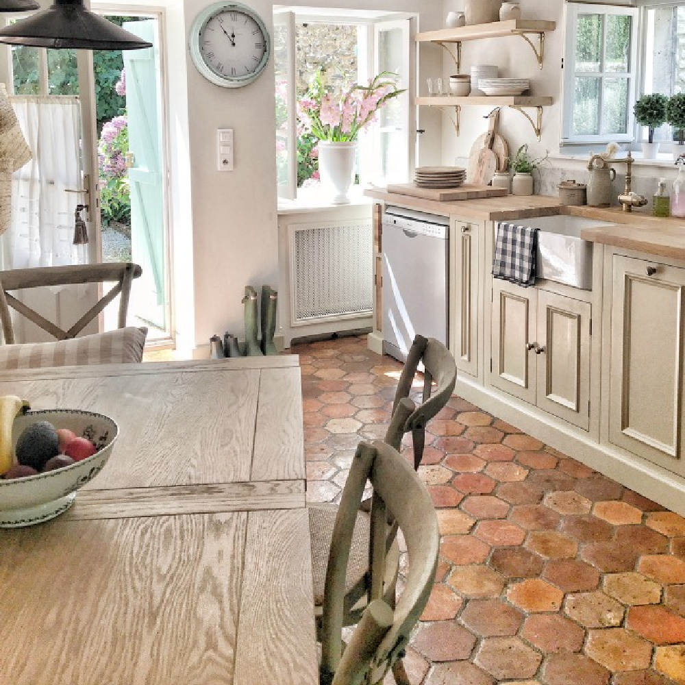 Open shelving, farm sink, reclaimed tile, and custom pendant light enhance the romantic charm of a restored French kitchen near Bordeaux. Vivi et Margot. #frenchkitchen #oldworldstyle #farmhousekitchen #europeancountry #rusticdecor #interiordesign #kitchens