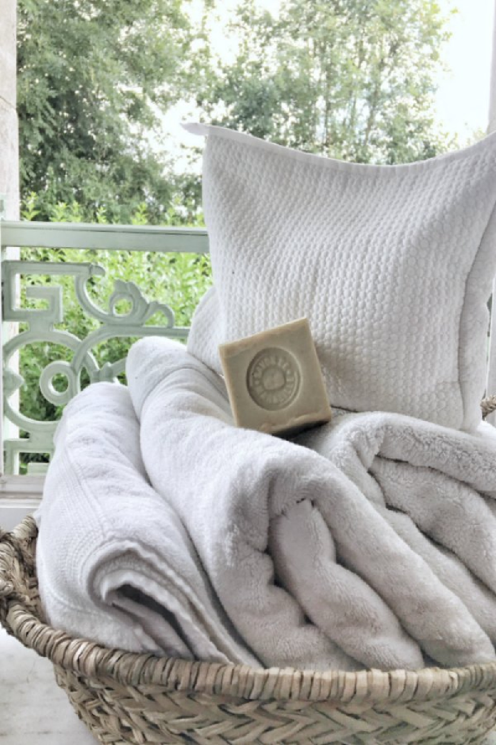 French market basket of towels and soap in a romantic French farmhouse bathroom by Vivi et Margot. #frenchfarmhouse #bathroomdecor  