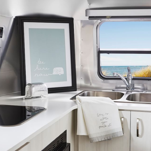 Retro camper with Be Here Now print. Airstream at Pottery Barn. #airstreaminterior #remodeledairstream