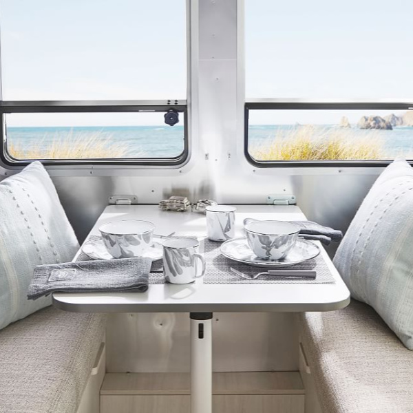 Grey dishes and linen. Airstream at Pottery Barn image of table and fold down benches.
