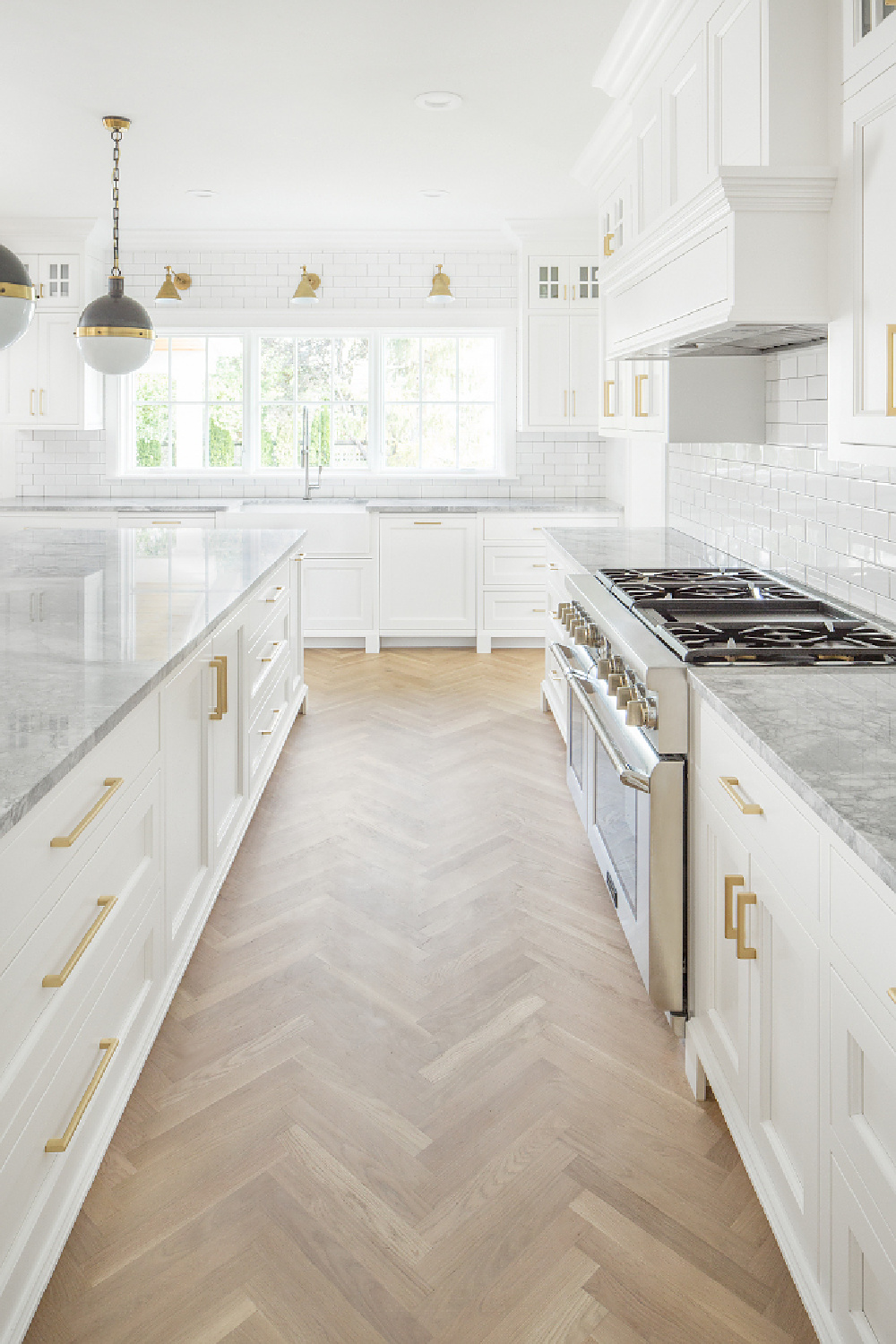 Modern farmhouse kitchen with Hicks pendants over island, herringbone wood floor, and brass library lights. Design by The Fox Group. Come BE INSPIRED by more Timeless Interior Design Ideas, Paint Colors & Furniture Finds. #thefoxgroup #kitchendesign #modernfarmhouse #herringbonefloor #hicks #islandpendants #timelessdesign