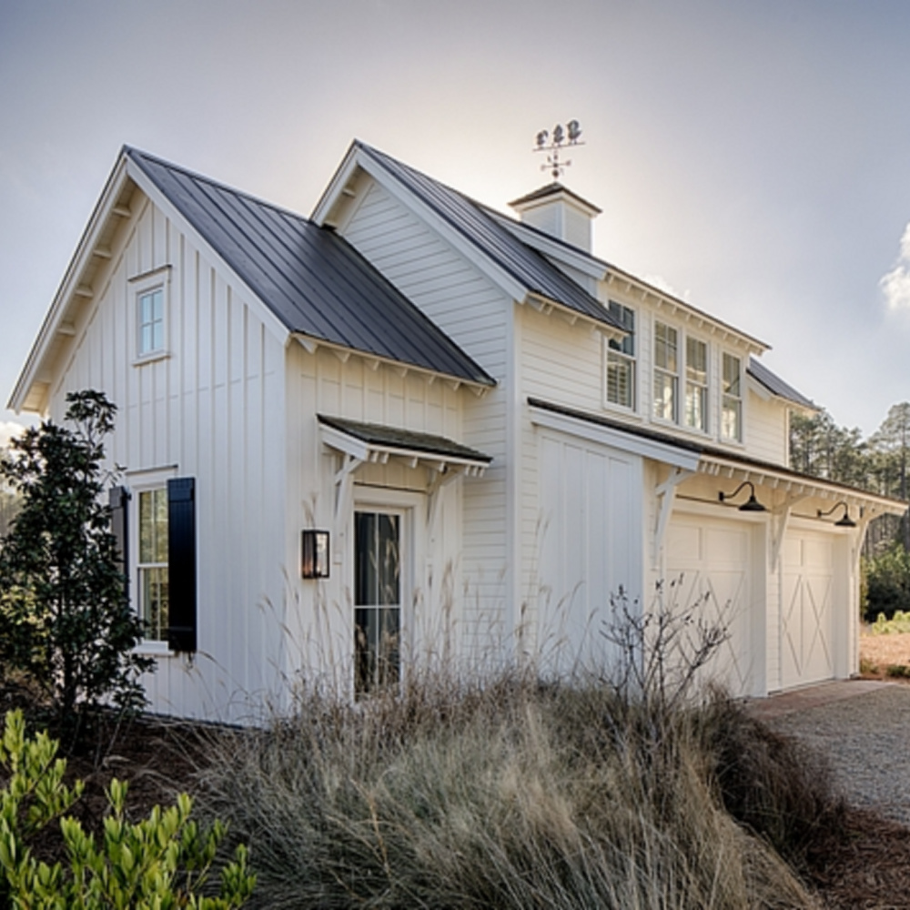 Board and batten coastal cottage exterior of a home in Palmetto Bluffs with interiors by Lisa Furey. #coastalcottage #boardandbatten #houseexteriors #whitecottage