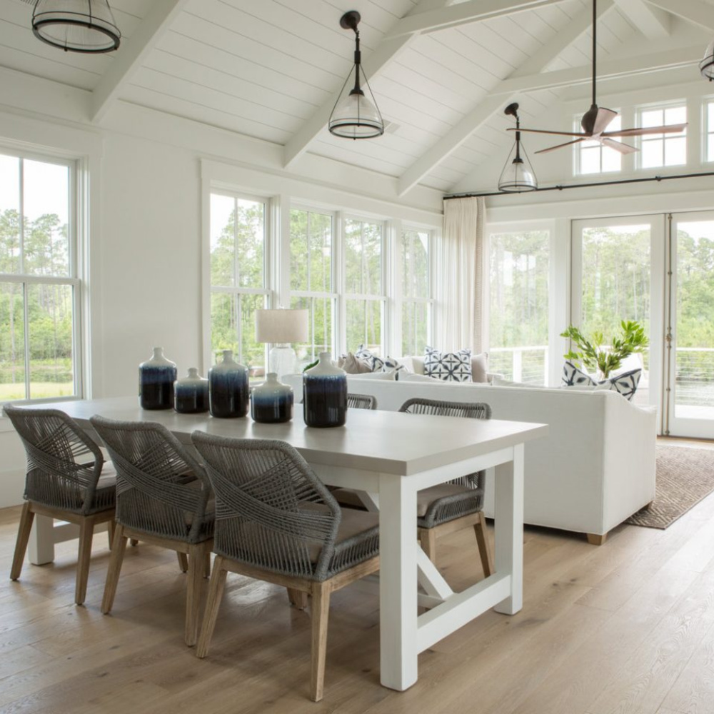 Great room and dining area iwith white oak flooring and shiplap n a board and batten coastal cottage in Palmetto Bluff. Modern farmhouse interior design by Lisa Furey. #coastalstyle #modernfarmhouse #interiordesign #greatroom #whiteoakflooring #shiplap #waterfronthome #coastalcottage