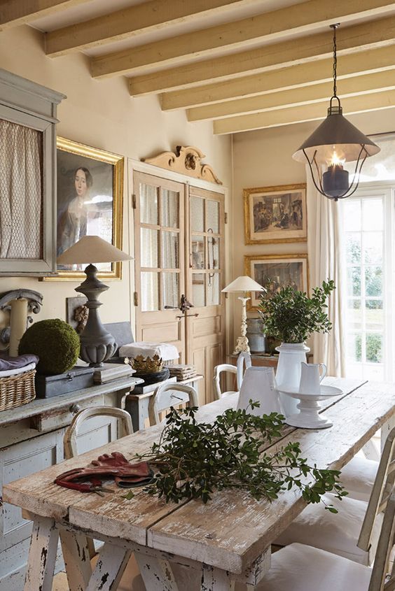 Charming French country kitchen with rustic elegant harvest table, architectural elements, and Old World style.