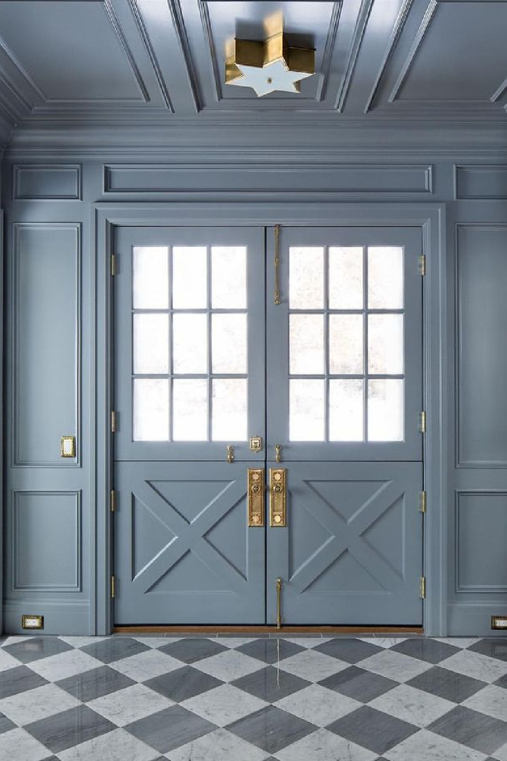 Blue grey painted paneling in a traditional home's entry with checkered flooring. Design by The Fox Group. #paneling #thefoxgroup #bluegray #entry #brasshardware
