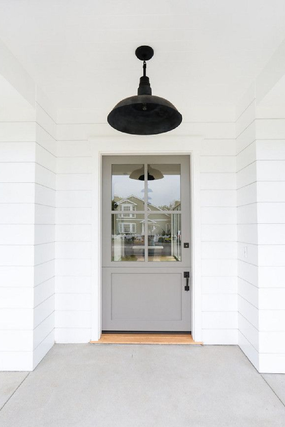 Galveston Gray Benjamin Moore paint color on front door of a beautiful home by The Fox Group. Barn style ceiling light. #thefoxgroup #benjaminmooregalvestongray #paintcolor #frontdoor #houseinspiration