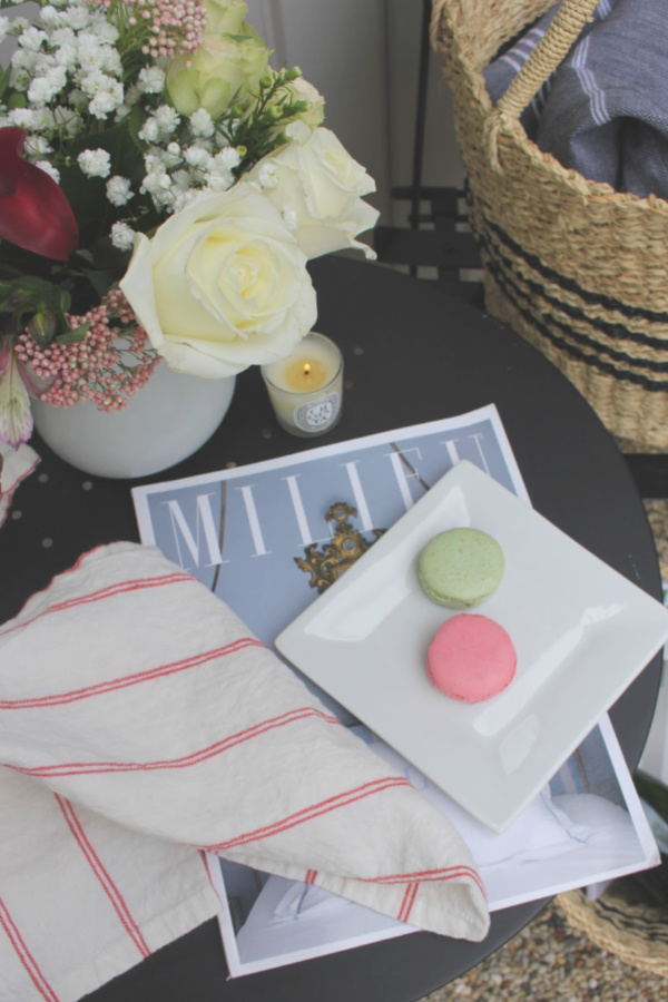 French country blissful vignette with macarons, spring flowers, Milieu magazine, and linen on a tabletop. #hellolovelystudio #frenchcountry #milieumoment #vignette #macarons