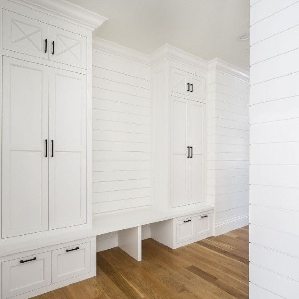 Classic white painted shiplap mud room with custom tall cabinetry flanking bench. Design by The Fox Group. #mudroom #thefoxgoup #shiplap #modernfarmhouse #benjaminmooresimplywhite