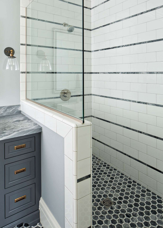 Stripe pattern on tiled showers walls in beautiful classic bathroom by The Fox Group. Hex tiles on shower floor. Come be inspired by more timeless interior design and paint color ideas! #bathroomdesign #thefoxgroup #stripes #timeless