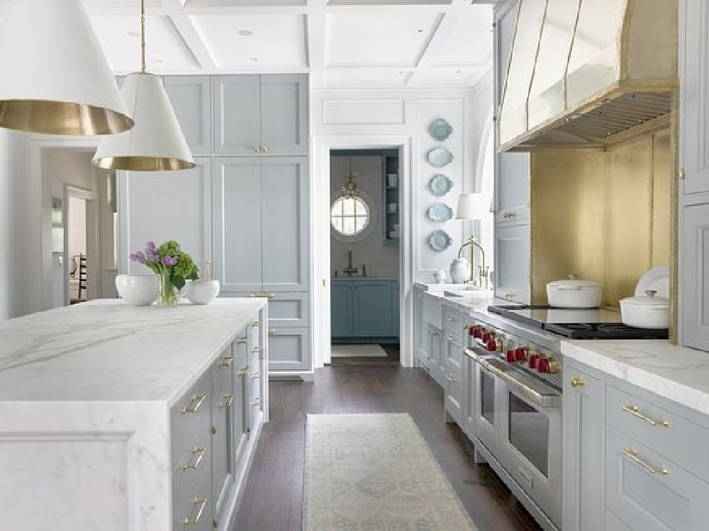 Traditional blue kitchen with pendants, brass hardware, plates, rug Shaker cabinet - Design Galleria. #bluekitchen #farrowandballlightblue #timelesskitchen #kitchendesign #traditionalkitchens