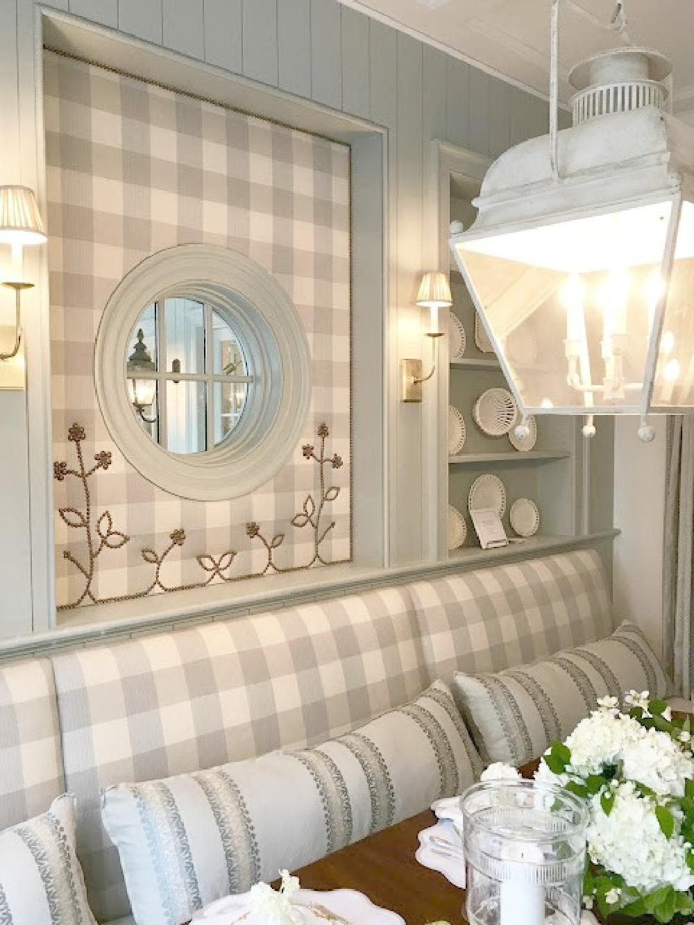 Blue and white Buffalo check upolstered wall and banquette in traditional kitchen breakfast room by Lauren DeLoach.  #buffalocheck #diningroom #interiordesign #lightblue #nailheadtrim #banquette #timelessdesign #traditionalstyle