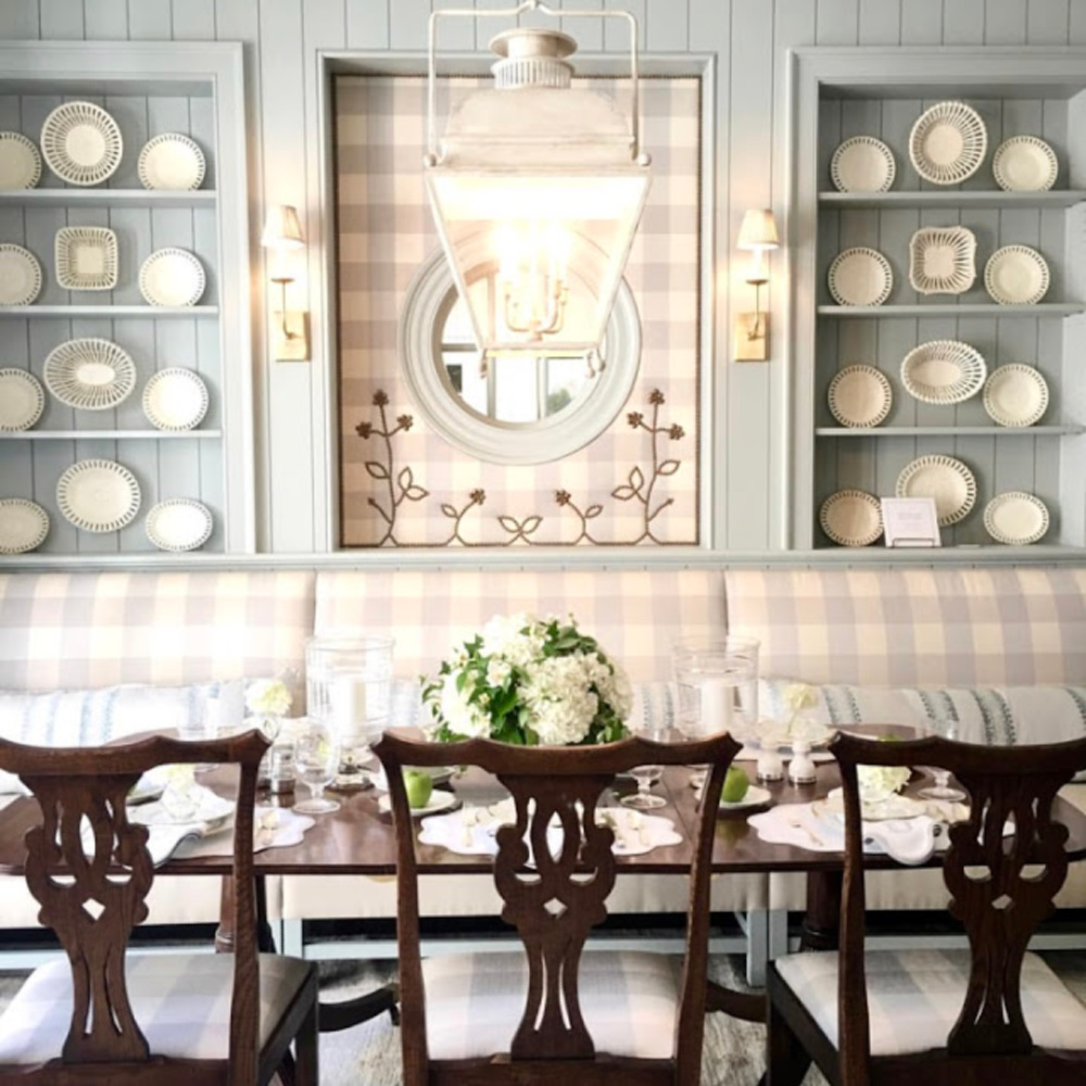 Stunning built-in blue painted shelves with lace creamware plates and banquette. #diningroom #traditionalstyle #buffalocheck #lightblue #interiordesign #banquette