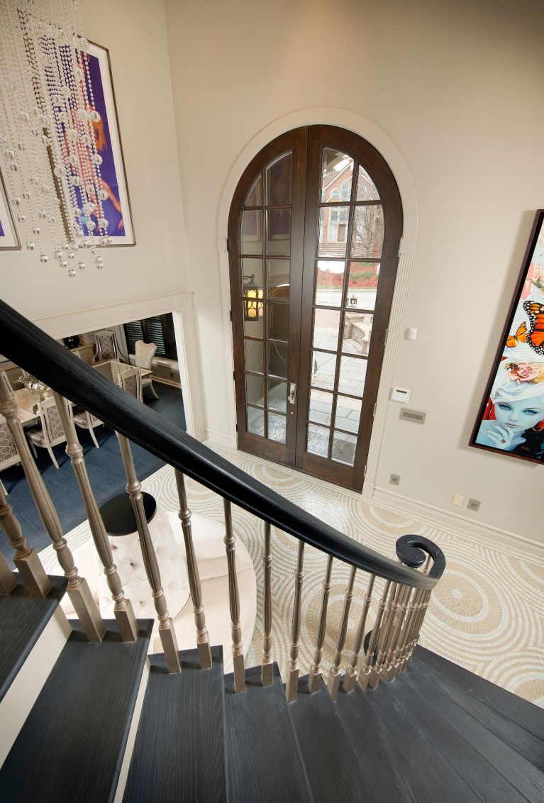 Stunning spiraling wood staircase with custom gray white oak hardwood (Carlisle) in a home infused with pop culture art and design. #flooring #interiordesign #staircase #whiteoak #hardwoodfloor #grayfloor #carlisle