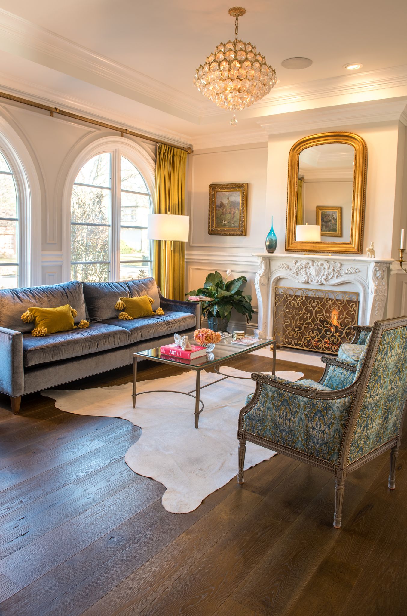 Elegant French inspired living room with Louis style fireplace and beautiful warm brown hardwood flooring by Carlisle. #fhardwoodloors #interiordesign #hardwoodfloor #carlisle