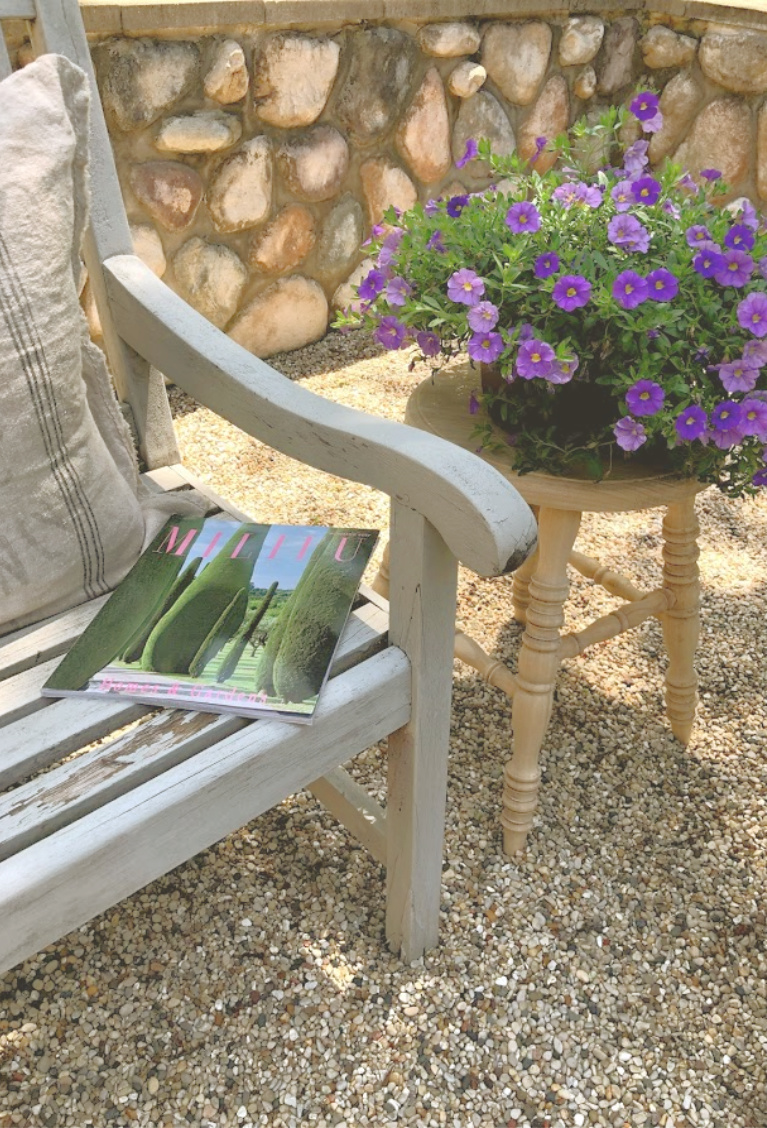 Weathered wood bench in my French country courtyard with wood rustic stool used as planter stand. #hellolovelystudio #rusticstool #courtyard #frenchcountry