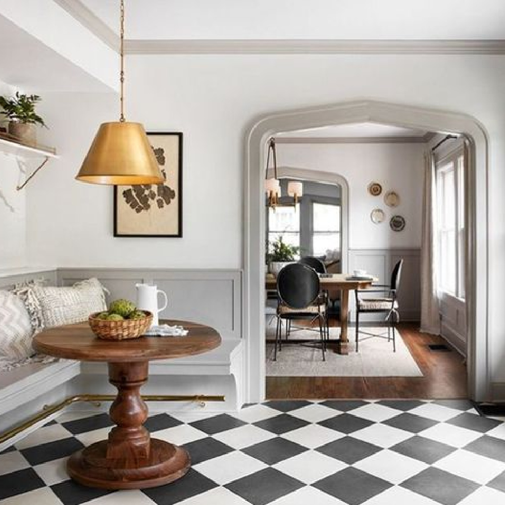 Scrivano fixer upper cottage breakfast nook with European inspired design, black and white check floors, light grey trim, white walls, modern lighting, and romantic timeless style. #homedecor #vintagestyle #fixerupper #kitchendesign #vintagekitchen #europeancountry