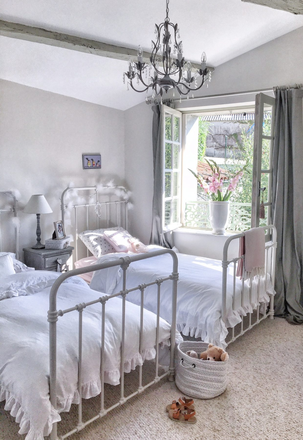 Charming French farmhouse girl's bedroom with iron panel beds and windows open to countryside - Vivi et Margot. #frenchfarmhouse #bedrooms #girlsbedroom