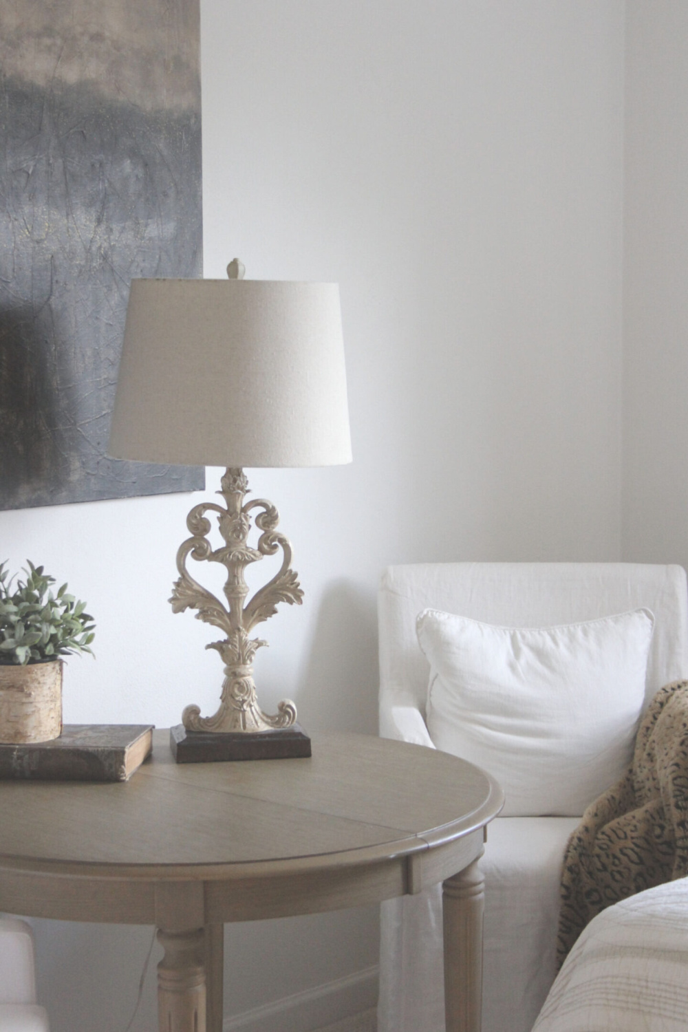 An abstract painting by me on a white wall in a bedroom with white linen slipcovered chairs and farm table - Hello Lovely Studio. #benjaminmoorewhite #paintcolors #interiordesign