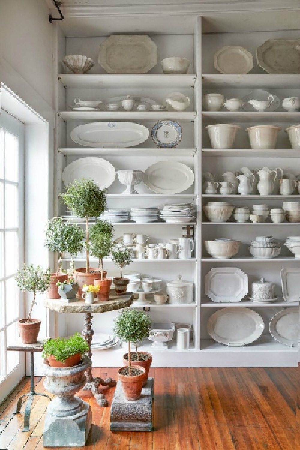 The charm of vertical built-in shelves in a vintage style kitchen is hard to beat! Ironstone, white dishware, and stoneware look elegant massed in this country style space with #shabbychic appeal. #ironstone #whitedecor #farmhousestyle
