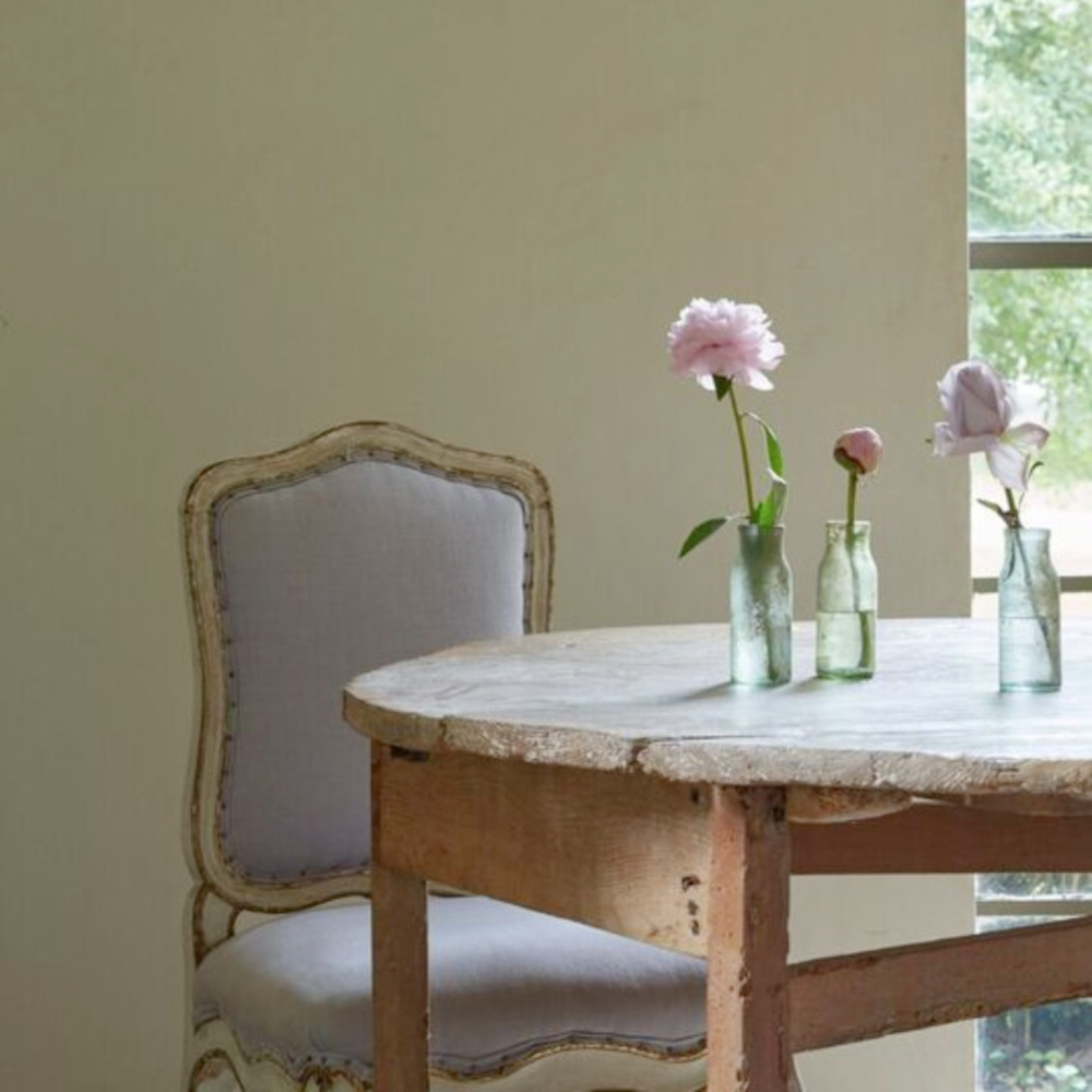 Rustic round antique farm table accented with lovely and simple bottle vases - Chateau Domingue. #frenchcountry #romanticinteriors