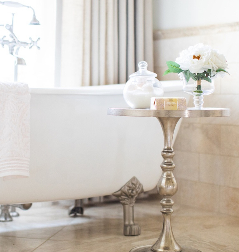 Romantic clawfoot tub in luxurious French country bathroom with travertine tile - Brit Jones. #frenchcountry #bathroomdecor #clawfoottub #romanticbathroom #interiordesign