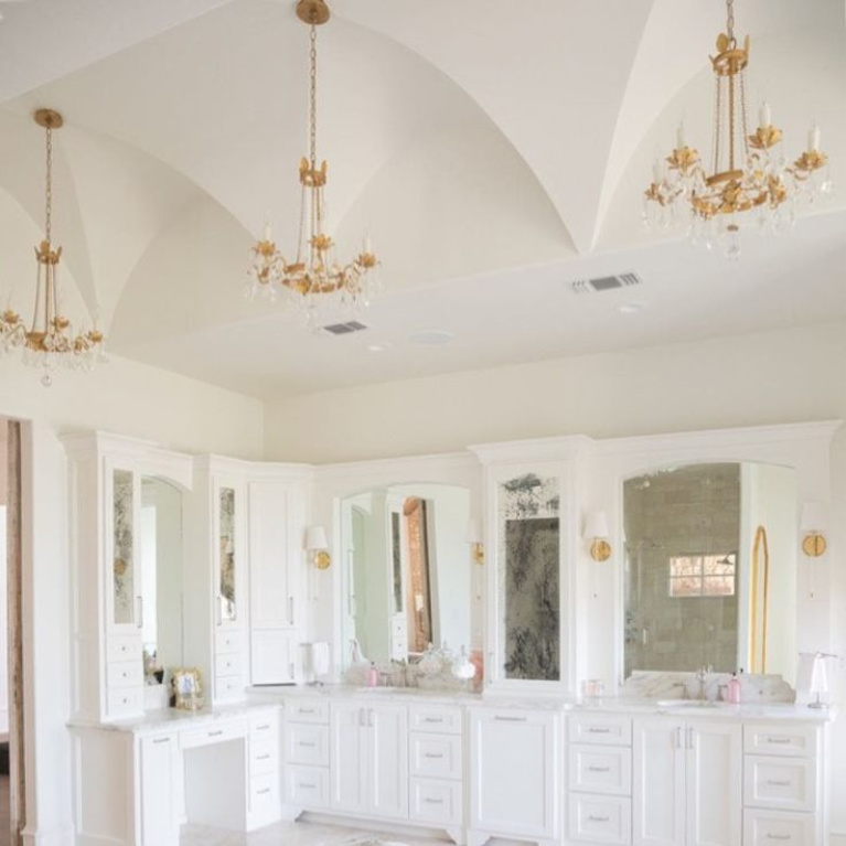 Elegant gold toned French country crystal chandeliers (Troy Viola) in a bathroom design by Brit Jones. #frenchcountry #interiordesign #bathroomdesign #chandeliers #romanticdecor