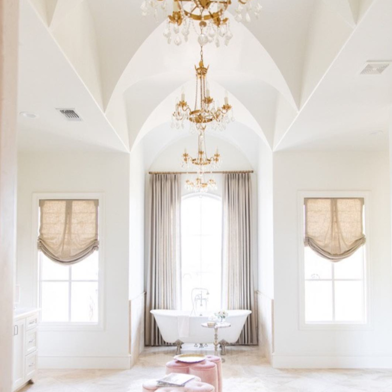 Elegant gold toned French country crystal chandeliers (Troy Viola) in a bathroom design by Brit Jones. #frenchcountry #interiordesign #bathroomdesign #chandeliers #romanticdecor