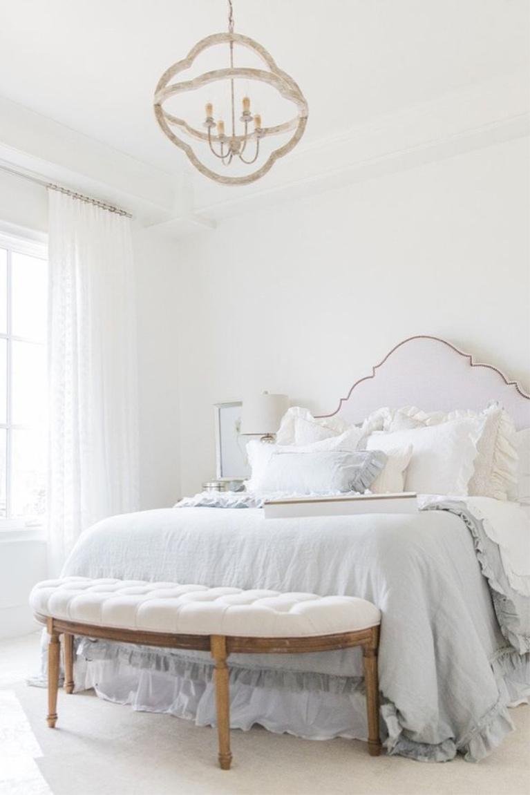 Elegant, romantic and serene French country bedroom with upholstered headboard and white drapes - Brit Jones. #interiordesign #romanticdecor #bedroomdecor #frenchcountry #whitebedrooms